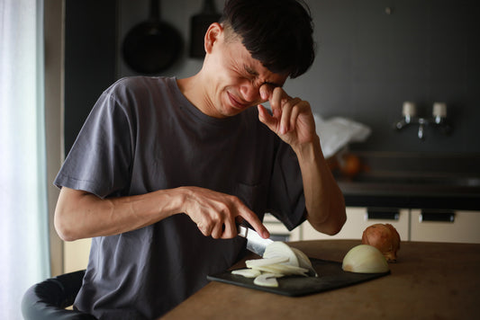 Man crying while cutting onions